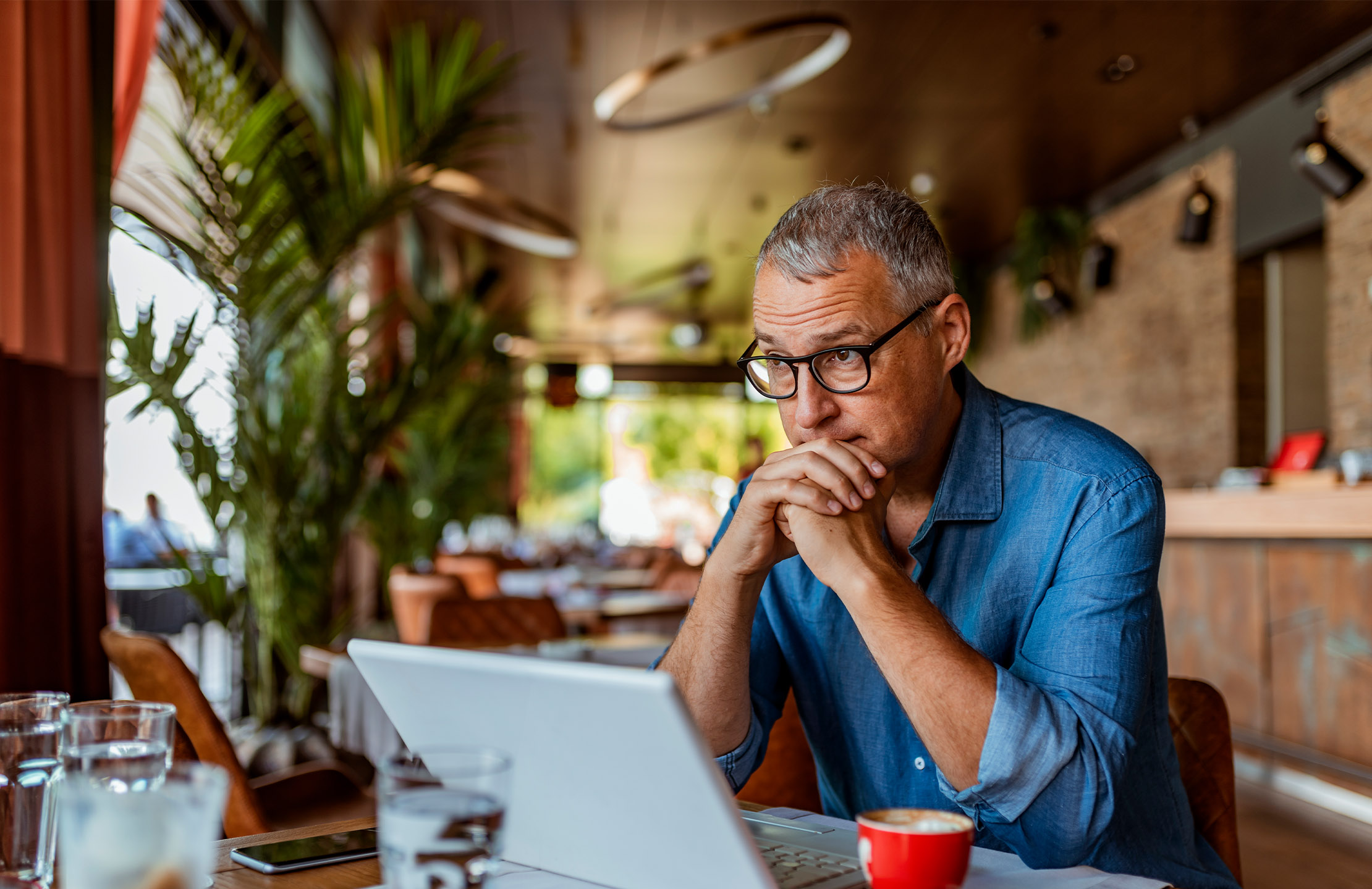 A man looking at his laptop with concern on his face